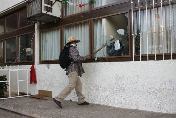 Algunos manifestantes con el rostro cubierto se dirigieron a la alcaldía de Iguala para lanzar piedras.