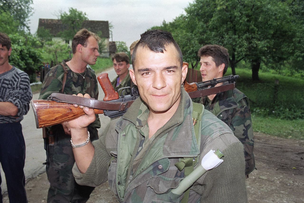 Esta guerra se cocinó cuando en 1980 el dictador comunista Josip Tito murió y la represión con la que había mantenido unida por décadas a Yugoslavia desapareció. En la fotografía tomada en plena guerra civil, un miembro de las fuerzas de defensa territoriales croatas lleva un rifle de asalto y una granada para vigilar junto a sus compañeros la aldea de Hrastovica, unas 40 millas al sur de Zagreb, la capital de Croacia. Julio de 1991.