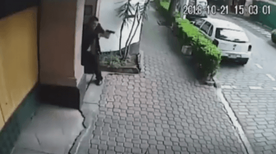 Un guardaespaldas del cardenal apunta con una pistola.