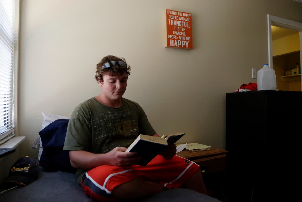 Blake Oppenheimer, de 23 años, lee en su dormitorio dentro del Recovery Boot Camp en Delray Beach (Florida). Antes de llegar allí, lo estafaron en un supuesto centro de recuperación, que luego fue cerrado por las autoridades. "Sentí como si era algo en una tienda que simplemente era vendido una y otra vez. 
<b>No les importa si mueres.</b> Simplemente desean seguir pasando esa tarjeta del seguro para sacarte más dinero", cuenta sobre esa experiencia.