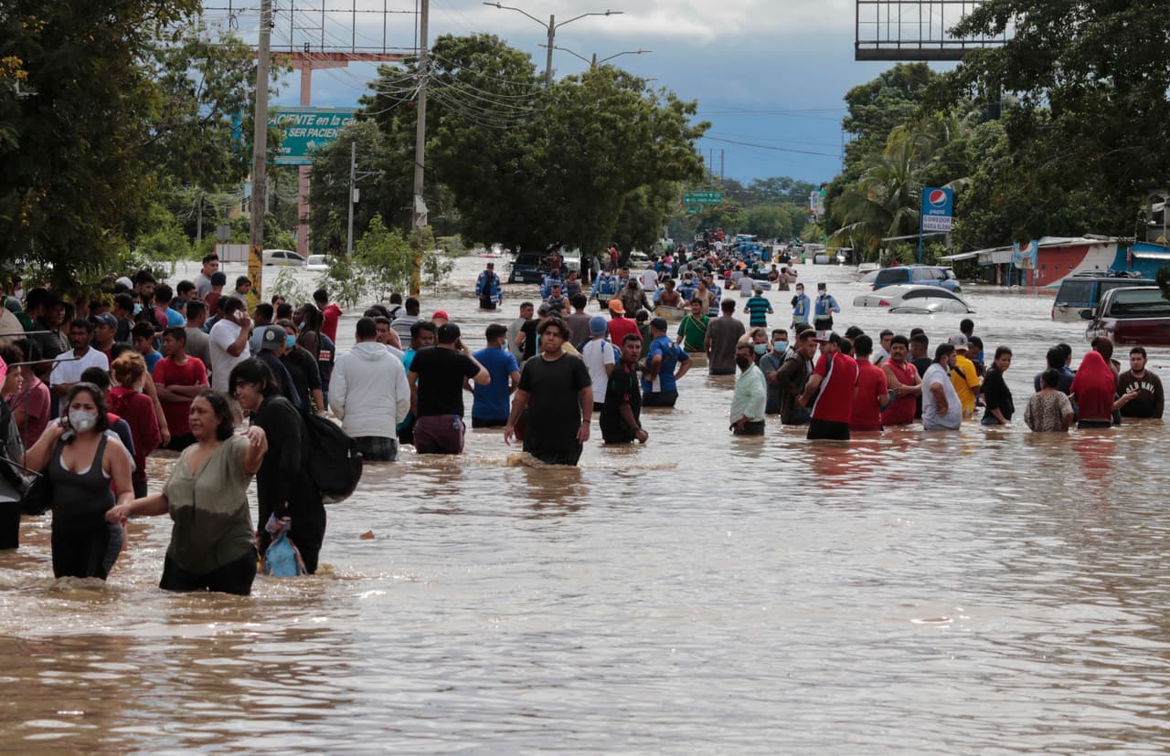 Residentes de Planeta, en Honduras, caminan por las calles inundadas de la ciudad. Actualmente Eta se encuentra a 65 millas (105 km) al este de la ciudad de Belice y tiene vientos máximos de 35 millas por hora (55 kmph).