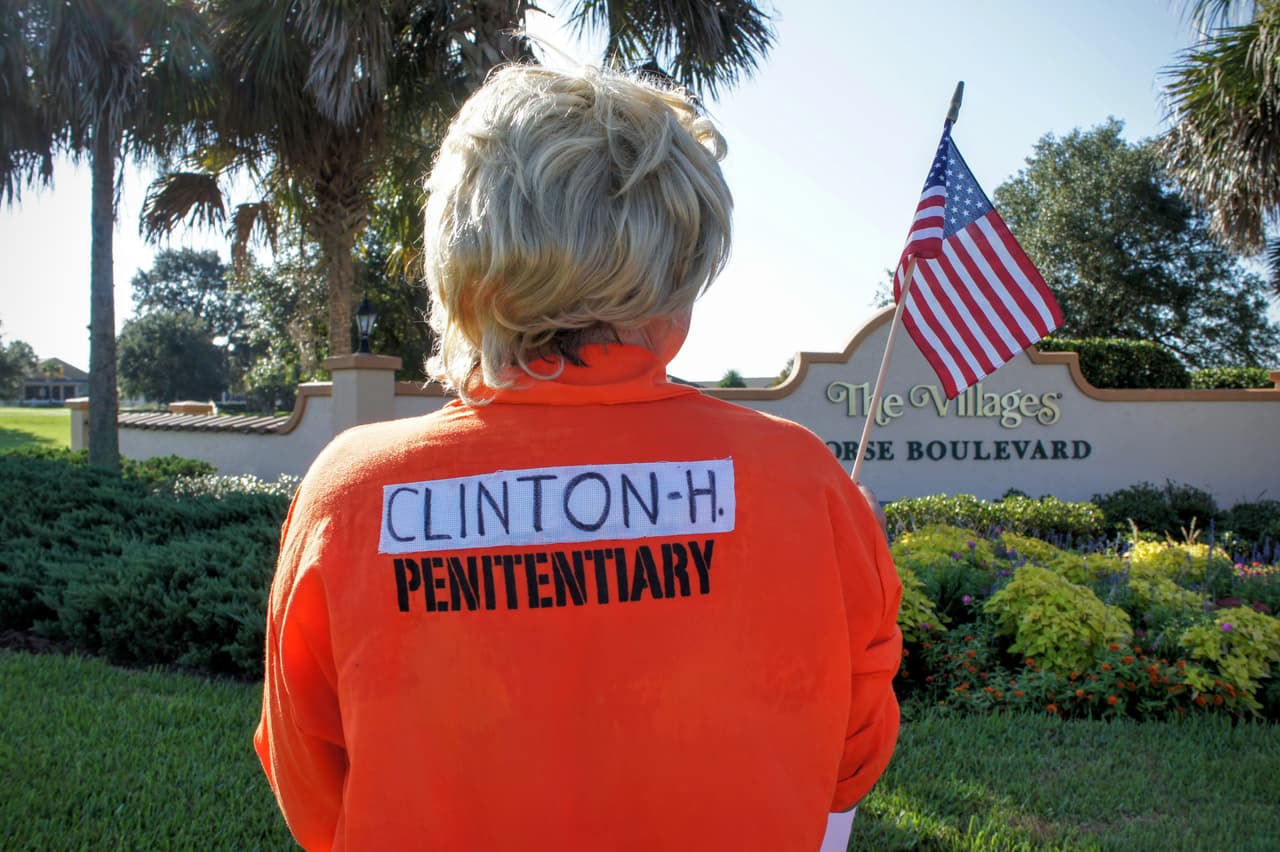 A Trump supporter dresses as Hillary Clinton in a prison suit.