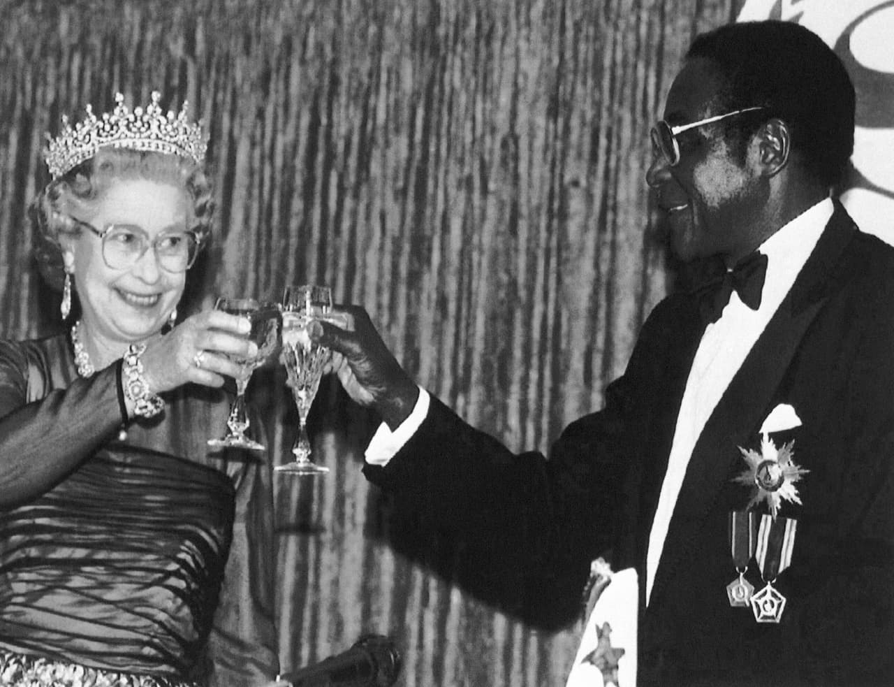 La reina Isabel II de Inglaterra brinda Con Robert Mugabe en una visita oficial a Zimbabue en 1991. La lucha de Robert Mugabe lo llevo a fundar la Unión Africana de Zimbabue en la década de 1960, algo que fue apoyado por movimientos de izquierda de todo el mundo. Luego se transformó en el partido ZANU-PF, de ideología socialista, con el que gobernó desde 1980 y que le exigió renunciar en 2017.
<br>