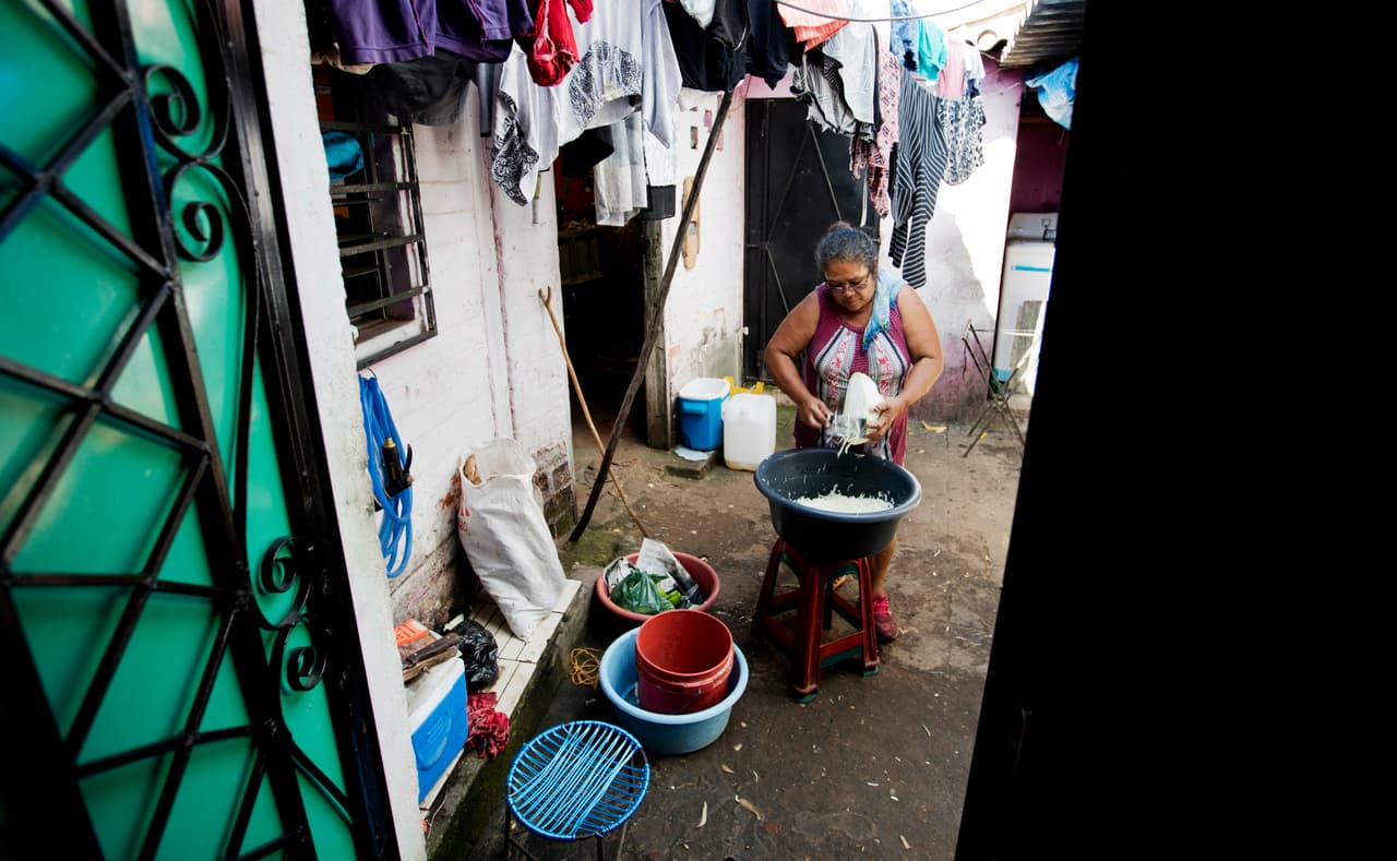 En esta foto del 10 de octubre de 2019, María Teresa Carballo, corta el repollo dentro de su casa en Santa Ana, El Salvador. Carballo vive en un vecindario controlado por una pandilla, pero todas las mañanas a las 5 a.m. viaja al mercado central de la ciudad, que está controlado por otra pandilla, para comprar yuca, plátanos y papas para ganarse la vida con las papas fritas que vende.