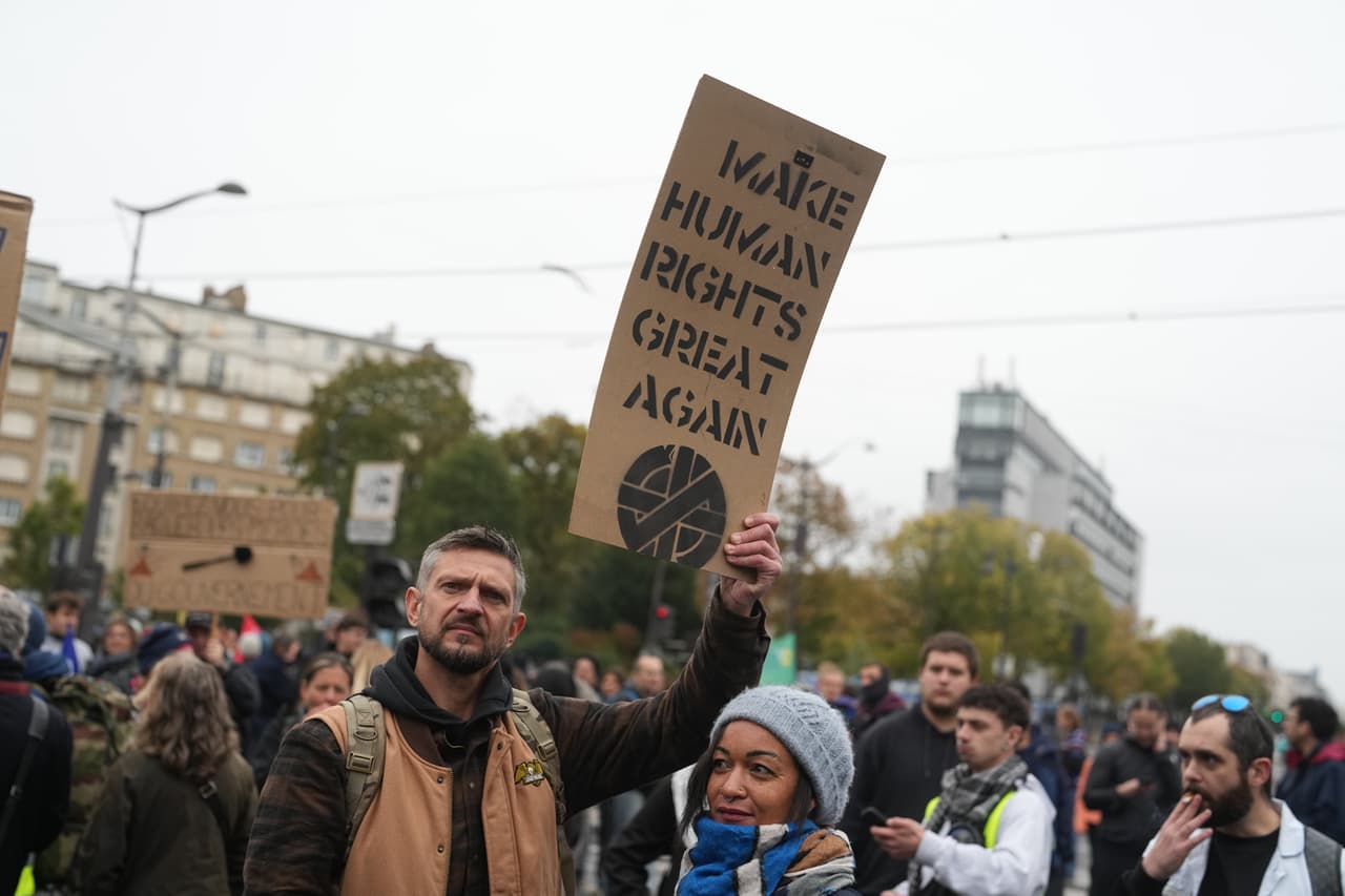 Un manifestante parisino sostiene una pancarta que dice "Hagamos los Derechos Humanos grandes otra vez".