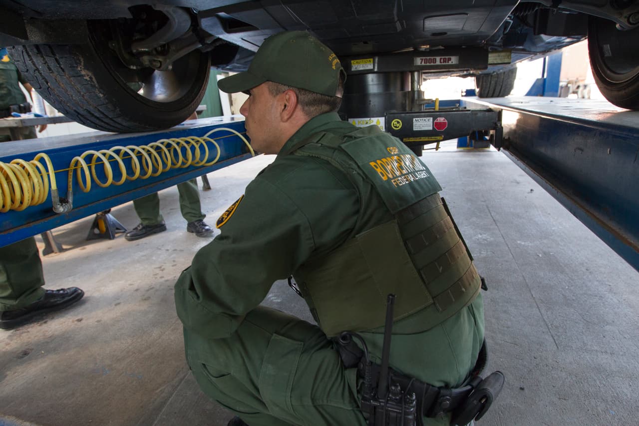 Un agente de la Patrulla Fronteriza revisa un carro donde podría estar escondida la droga.