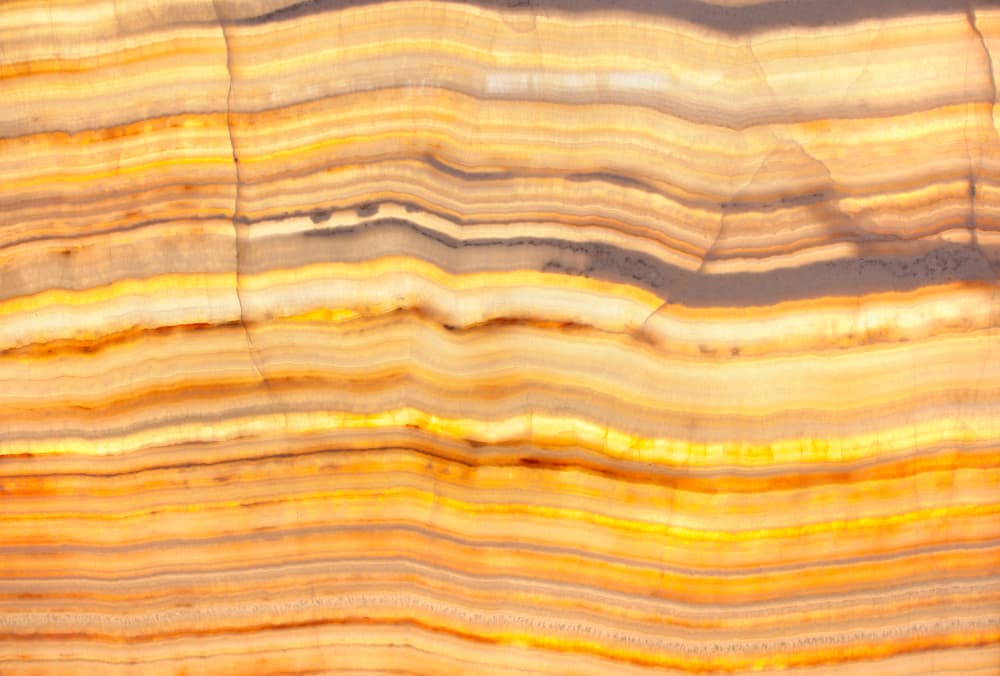 Puede llegarse a confundir el ónix con la ágata, la cual es otra roca calcárea muy parecida y que también ocurre en bandas de colores diferentes. La única diferencia que separa al ónix de la ágata es la calidad de estas bandas que las conforman. Este es un ónix amarillo mezclado con algo de mármol.