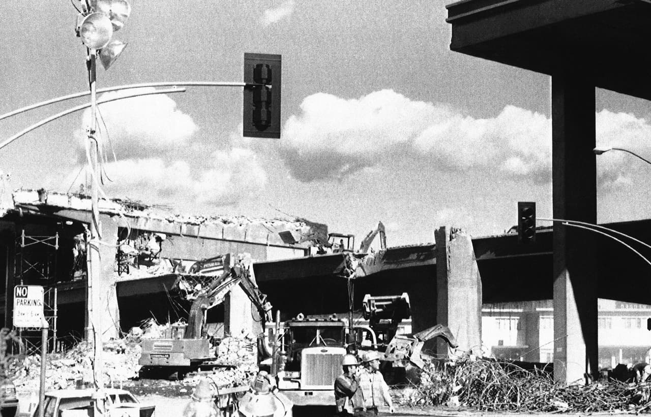 En esta imagen del 25 de octubre de 1989, equipos de emergencia trabajan en la demolición de las partes del viaducto elevado de Oakland que quedaron en pie. A las familias que vivían cerca de la autopista les tomó varios días poder regresar a sus viviendas.