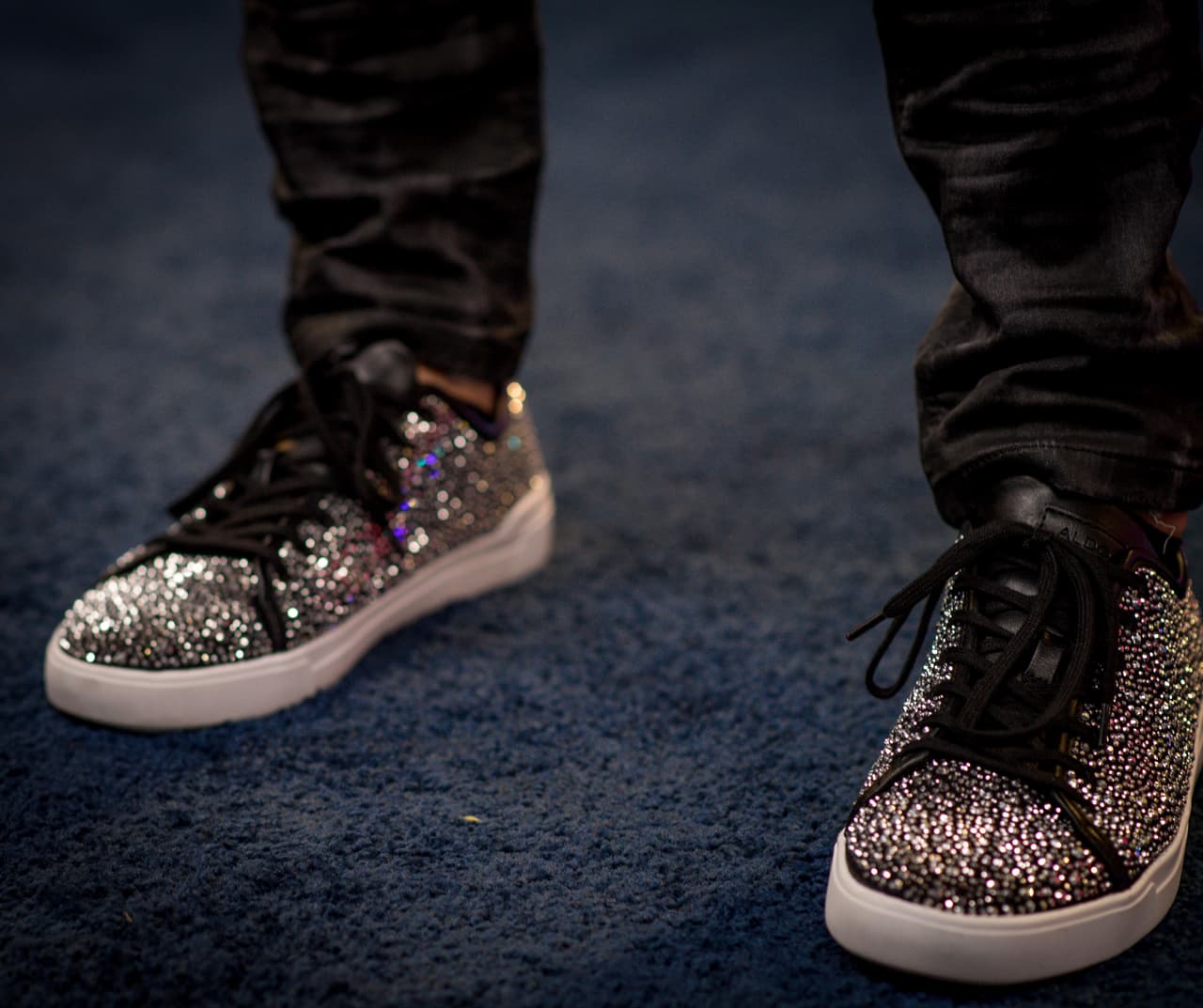 En los pies llevó unos tenis de lentejuela plateada sobre negro de la marca ALDO.