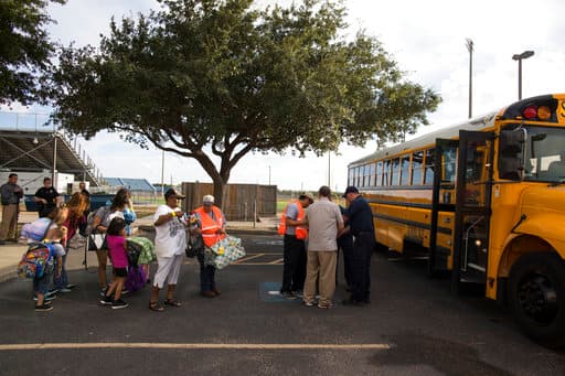 Varias personas se preparan para subir a un autobús en el Centro de Natación de Corpus Christi porque serán trasladadas a San Antonio antes de que el huracán Harvey toque tierra en Texas. Las autoridades de varios condados costeros de Texas ordenaron evacuaciones obligatorias debido al peligro que representa la tempestad para la zona.