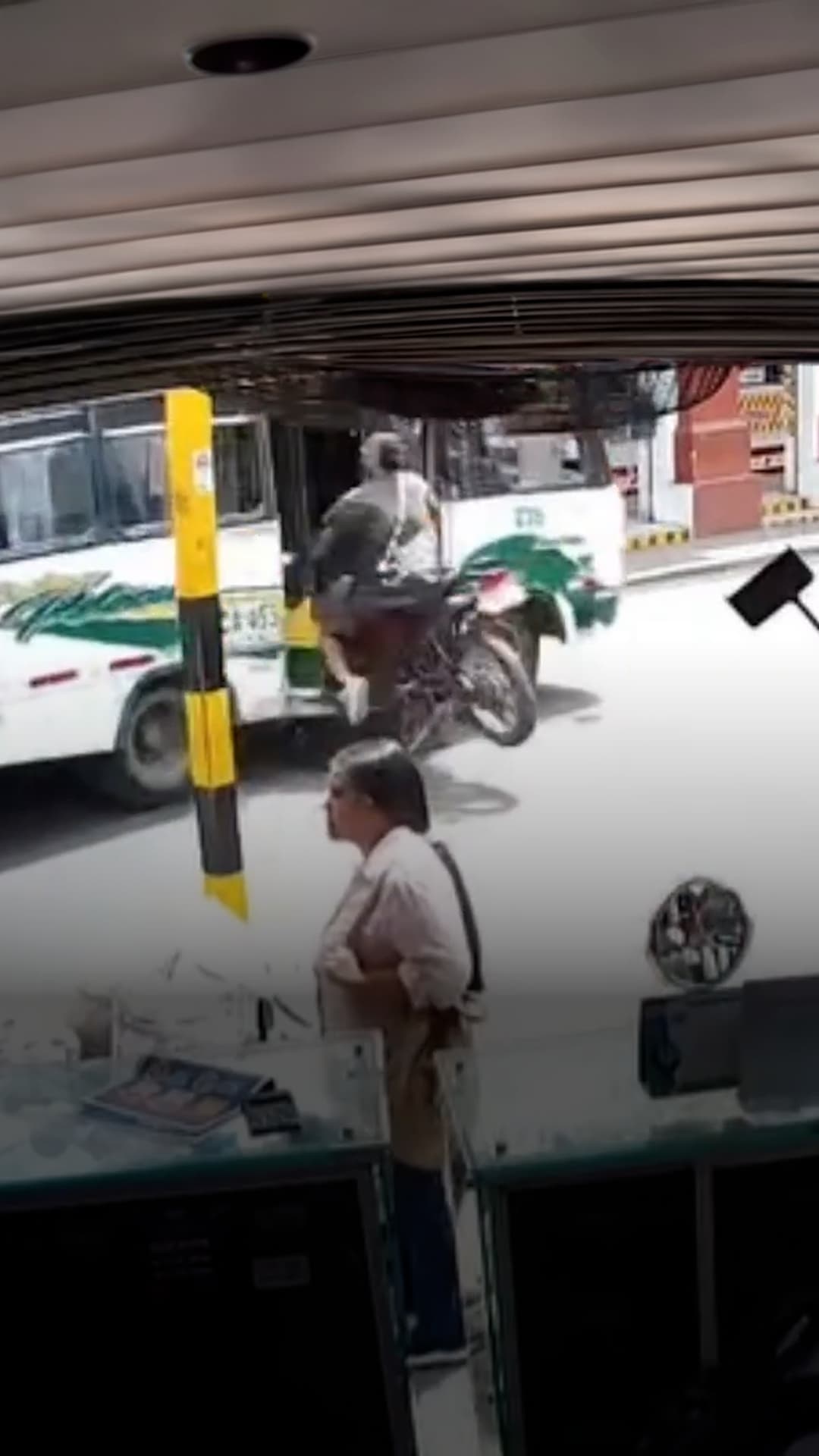 Un motociclista choca y termina dentro de un autobús