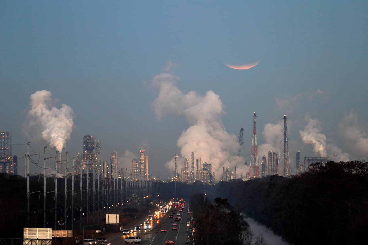 El eclipse de superluna del 31 de enero de 2018 visto sobre las refinerías de petróleo humeantes de Louisiana, EEUU. Las refinerías emiten grandes cantidades de gases tóxicos contaminantes y vierten residuos a las aguas.
