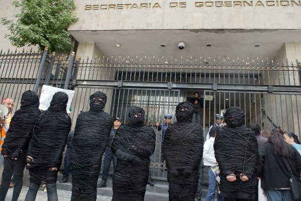 En la protesta varios activistas se envolvieron con hilo negro de pies a cabeza para representar el drama de la pérdida de rostro e identidad que sufren los muertos y desaparecidos en México.