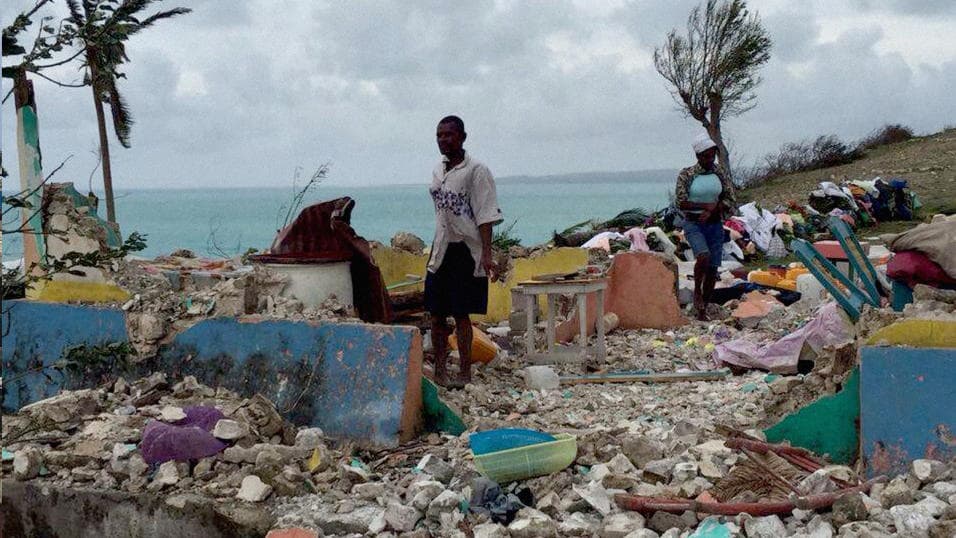 Un hombre y una mujer recogen los escombros de una casa en Ile-a-Vache después del paso del huracán Matthew. La isla de 10,000 personas sufrió daños masivos en los hogares.