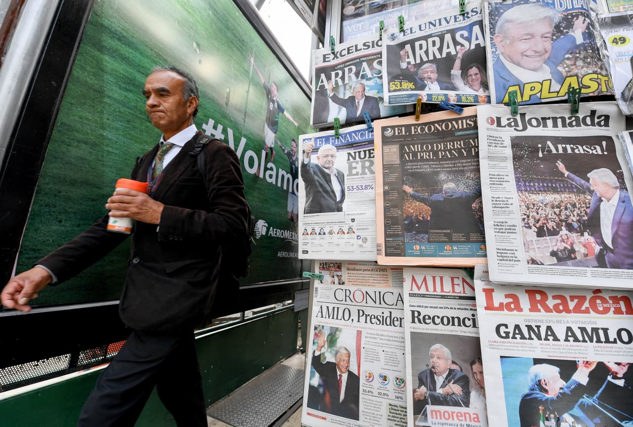 A man walks past a kiosk where newspapers fronted by the results of the presidential election in Mexico in which leftist Andres Manuel Lopez Obrador claimed victory, are sold in Mexico City, on July 2, 2018. - Anti-establishment leftist Lopez Obrador swept to victory in Mexico's presidential election Sunday, in a political sea change driven by voters' anger over endemic corruption and brutal violence. (Photo by ULISES RUIZ / AFP) (Photo credit should read ULISES RUIZ/AFP/Getty Images)