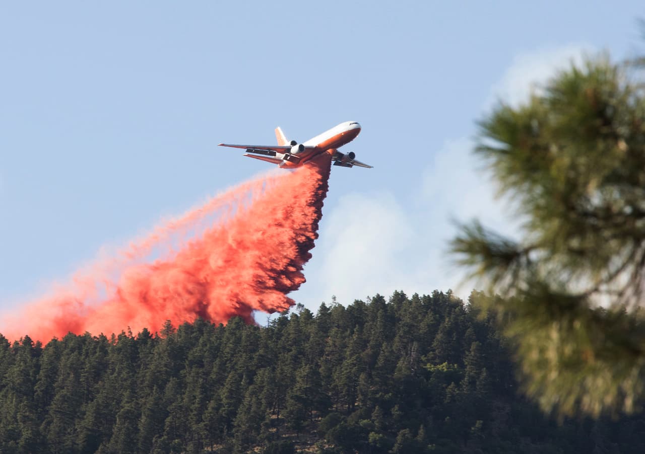 En esta fotografía del domingo 21 de julio de 2019, un avión lanza retardante en una zona cercana a un incendio forestal en Flagstaff, Arizona.