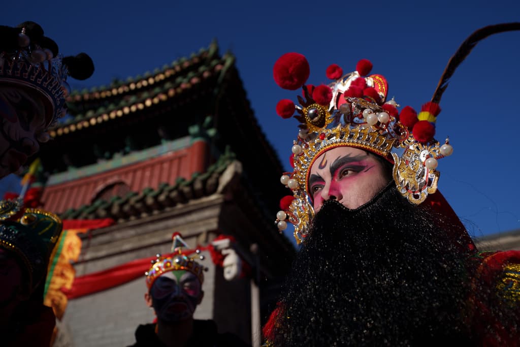 Bailarines de Yingge, una danza folclórica tradicional del sur de China, esperan en un templo en Pekín para su presentación.