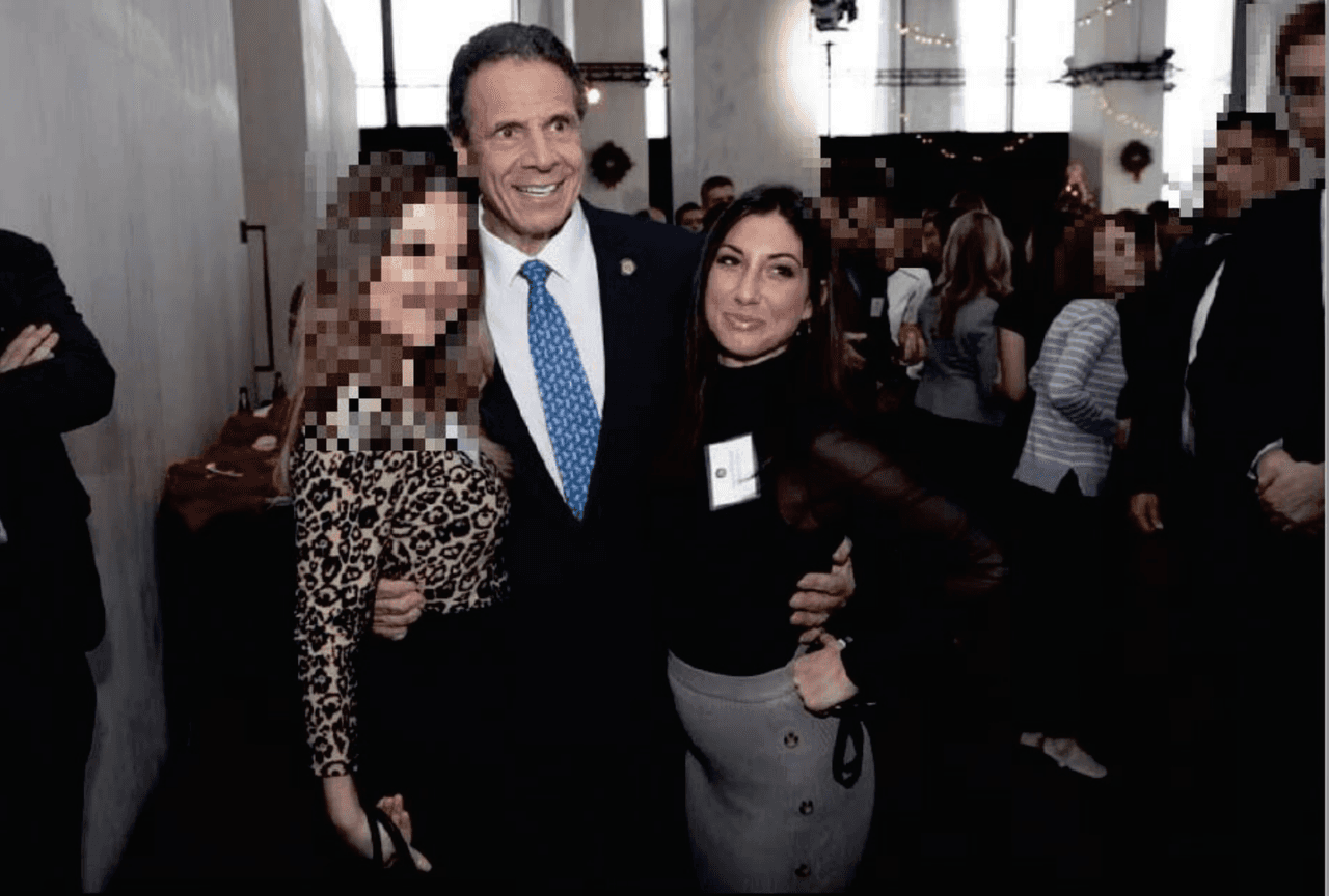 El informe describe un incidente en una fiesta navideña en la que, antes de hacerse una fotografía con Asistente Ejecutiva no. 1 y otra acusadora, Alyssa McGrath, el Gobernador besó a una de ellas en la frente y a la asistente ejecutiva nº 1 en la mejilla, y luego posó para una fotografía con las manos firmemente alrededor de la cintura de ambas mujeres, justo por debajo de sus pechos. (Imagen)