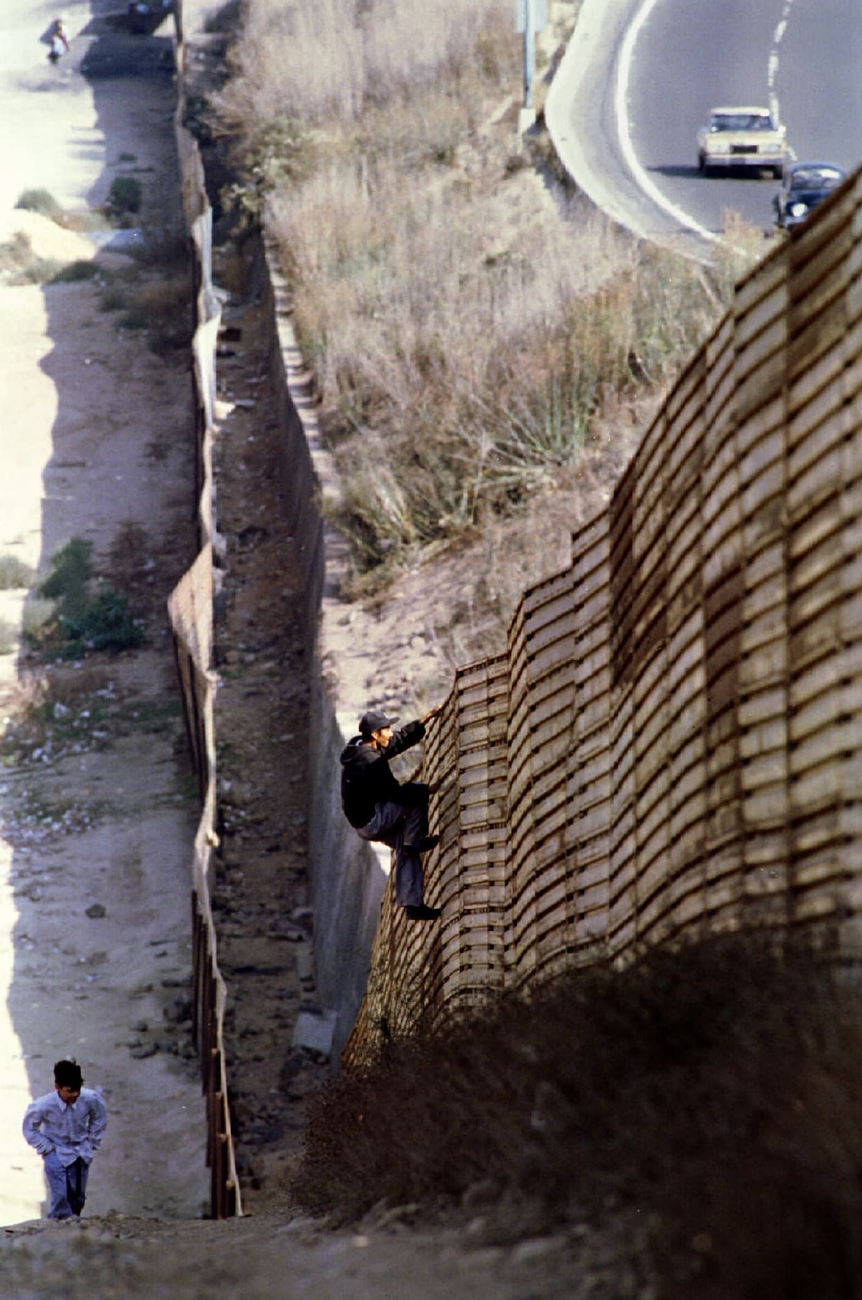 Un ciudadano mexicano de Tijuana escala la barda para regresar a su país el 26 de octubre de 1994. El primer muro fronterizo fue construido en 1990 en San Diego, California, en un intento por frenar el cruce de inmigrantes por esa zona. La pared entre San Diego y Tijuana, en el estado mexicano de Baja California, fue construida a lo largo de 20 kilómetros para abarcar desde el océano Pacífico hasta las montañas al este de ambas ciudades. 
<a href="http://www.univision.com/noticias/inmigracion/el-espinoso-asunto-de-los-muros-fronterizos-entre-estados-unidos-y-mexico">Vea aquí: El espinoso asunto de los muros fronterizos entre Estados Unidos y México.</a>