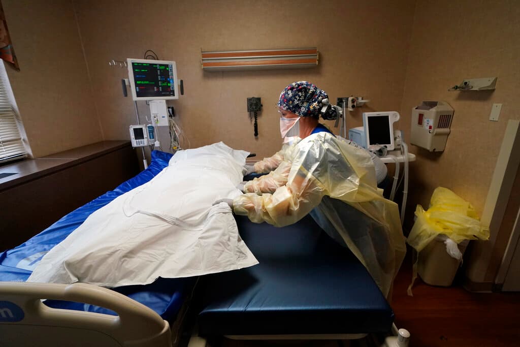 El personal médico traslada a un paciente de COVID-19 que murió a una camilla para llevarlo a una camioneta de la funeraria, en el Centro Médico Willis-Knighton en Shreveport, Luisiana, el 18 de agosto de 2021.