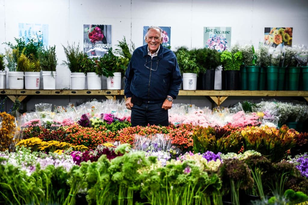 Morey Moss orgulloso frente a sus flores en la tienda que abrió en 1947.