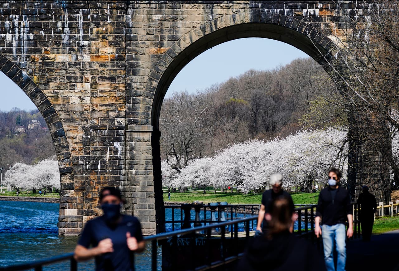 Un grupo de personas que usan máscaras faciales como precaución contra el coronavirus se ejercitan junto a los cerezos en Philadelphia. El presidente Joe Biden anunció que 
<a href="https://www.univision.com/noticias/salud/biden-adelanta-acceso-adultos-vacuna-coronavirus">adelanta al 19 de abril</a>l a fecha en la que los estados deben abrir a el acceso a la 
<a href="https://www.univision.com/temas/vacunas">vacuna </a>contra el 
<a href="https://www.univision.com/temas/coronavirus">coronavirus </a>para todos los que tengan de 16 años en adelante.