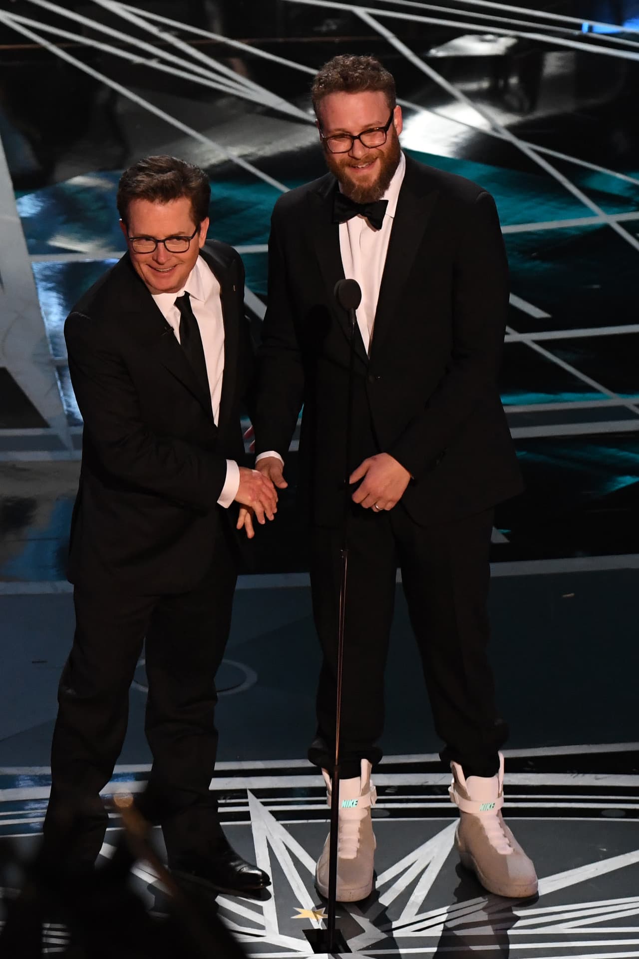 US actor Michael J. Fox (L) and Canadian actor Seth Rogen arrive on stage to present the award for Best Film Editing at the 89th Oscars on February 26, 2017 in Hollywood, California. / AFP / Mark RALSTON (Photo credit should read MARK RALSTON/AFP/Getty Images)