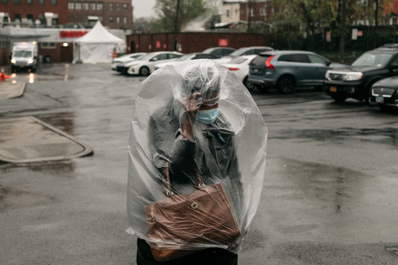 Una mujer cubierta con una bolsa de plástico frente al Centro Médico Kingsbrook Jewish, en Brooklyn, Nueva York. 13 de abril.