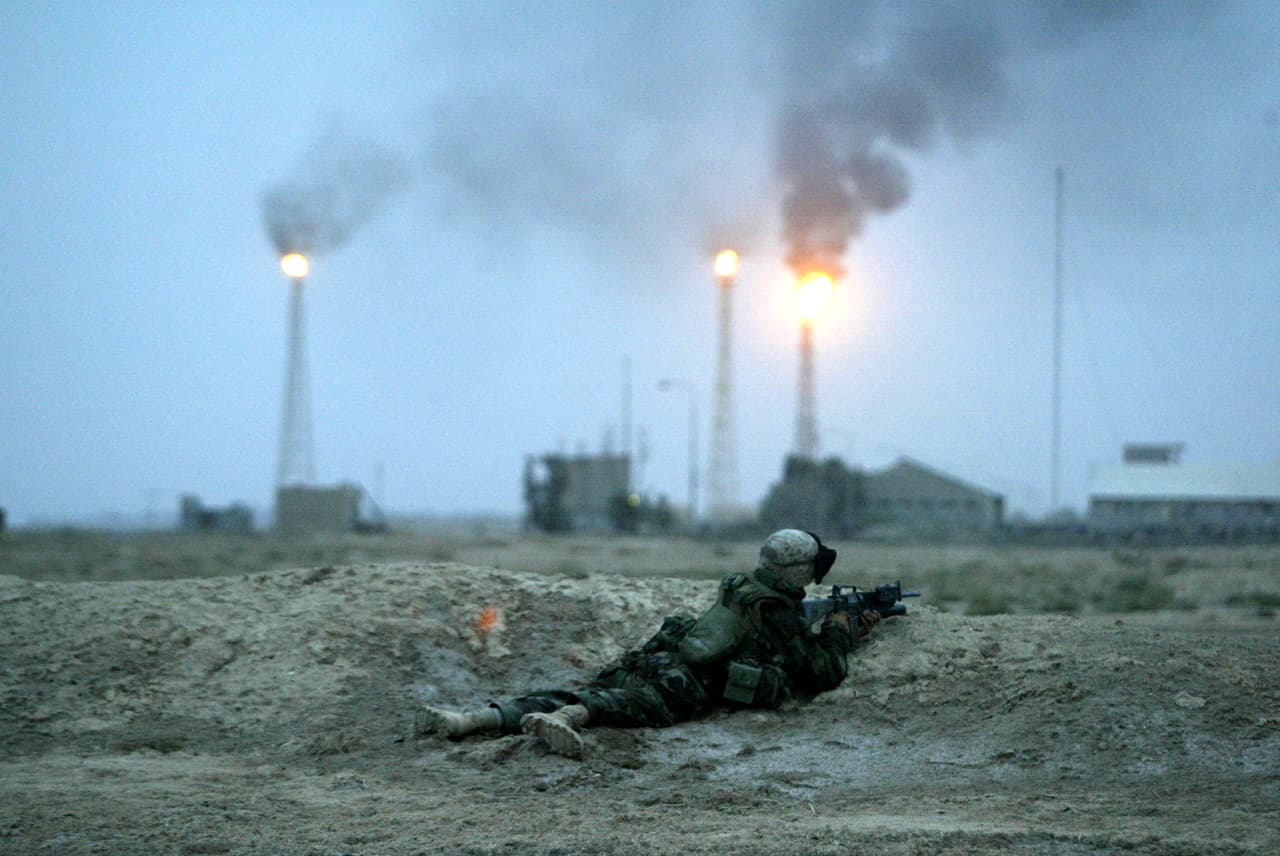 Mientras blancos militares iraquíes era destruidos por misiles estadounidenses, tropas británicas y de EEUU avanzaban hacia Bagdad desde Kuwait en el sur y los aliados kurdos iraquíes desde el norte. En la fotografía un soldado estadounidense combate a las afueras de una refinería de petróleo en Basora, cerca de la frontera con Kuwait, el 21 de marzo de 2003.