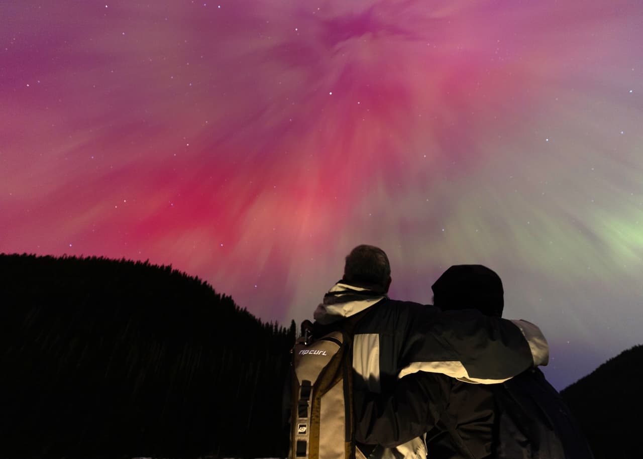 Una pareja observa la aurora boreal, comúnmente conocida como la aurora boreal el 11 de mayo de 2024 en Manning Park, Columbia Británica, Canadá. (Foto de Andrew Chin/Getty Images)