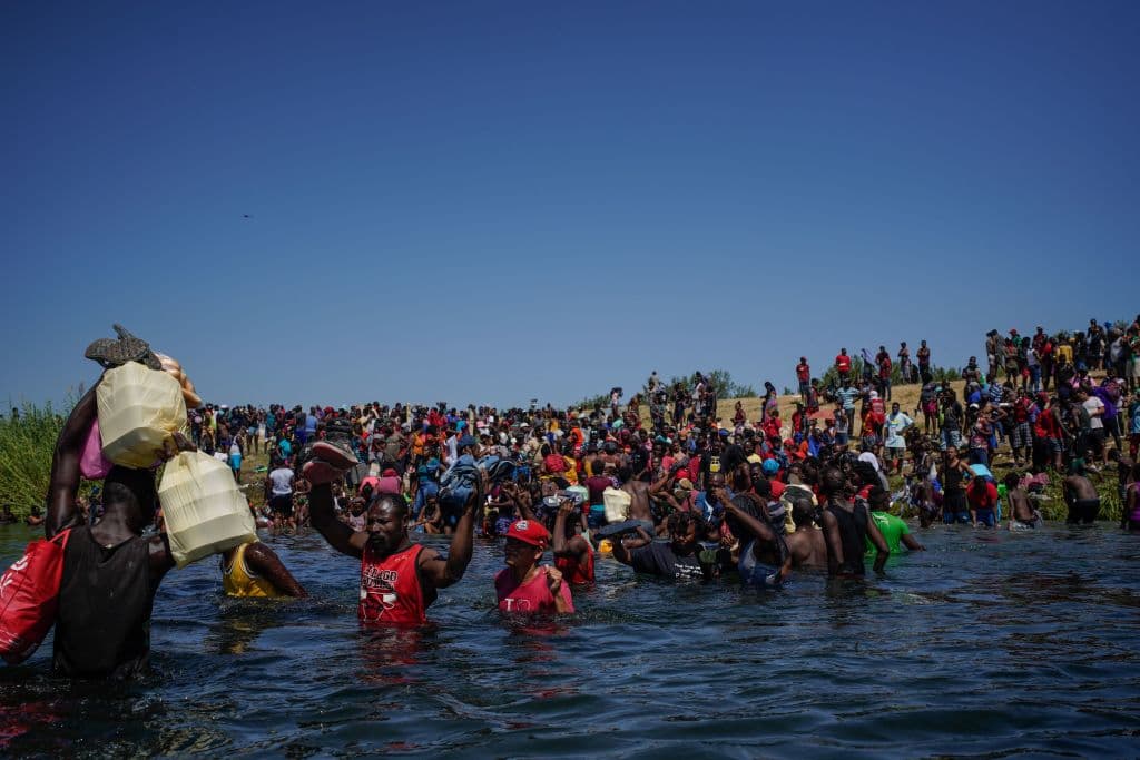 Haitian migrants cross the Rio Grande river to get food and water in Mexico, after another crossing point was closed near the Acuna Del Rio International Bridge in Del Rio, Texas on September 19, 2021.
