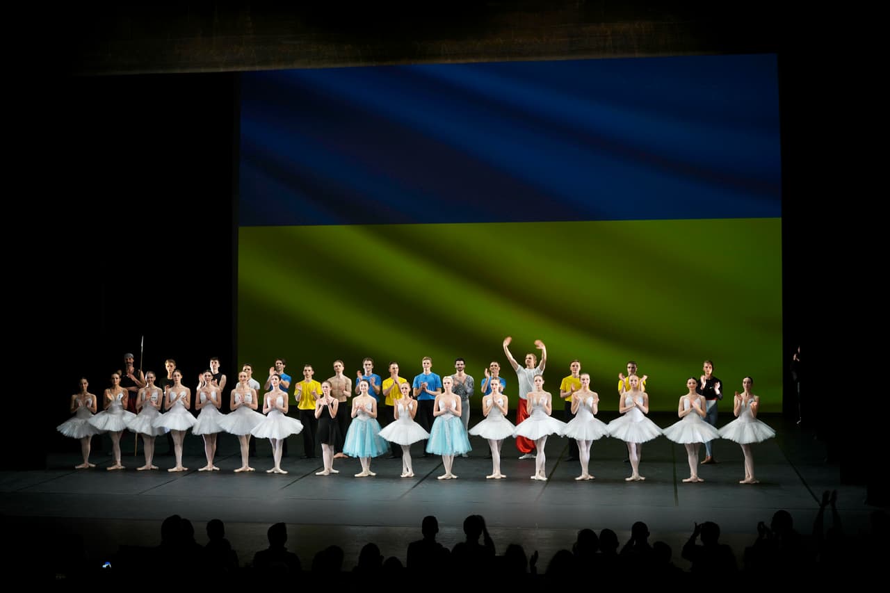 La compañía del ballet de la Ciudad de Kiev agradece la ovación del público al final del presentación. Al fondo, una bandera de Ucrania. Los bailarines ucranianos han buscado refugio en otros lugares: la Ópera Nacional de Rumanía ofreció a seis de los bailarines que huían de la guerra la oportunidad de trabajar con su cuerpo de ballet, y algunos de ellos podrían estar sobre el escenario en un mes.
<br>