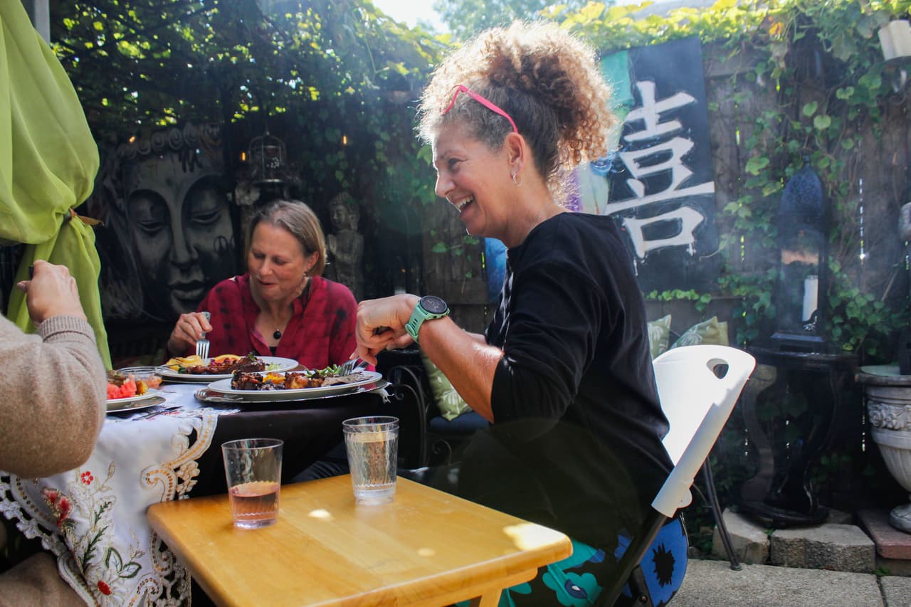 Para alegría de todos, el domingo 7 de septiembre fue un día soleado. Lisa Jarvis disfruta su comida con sus amigas en el comedor exterior de Sinhá.
<br>