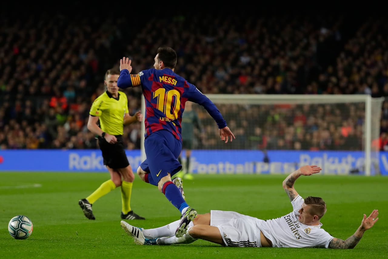 Lionel Messi gambetea a Toni Kross que intenta robar el balón con una barrida, el argentino se marcha con el esférico.