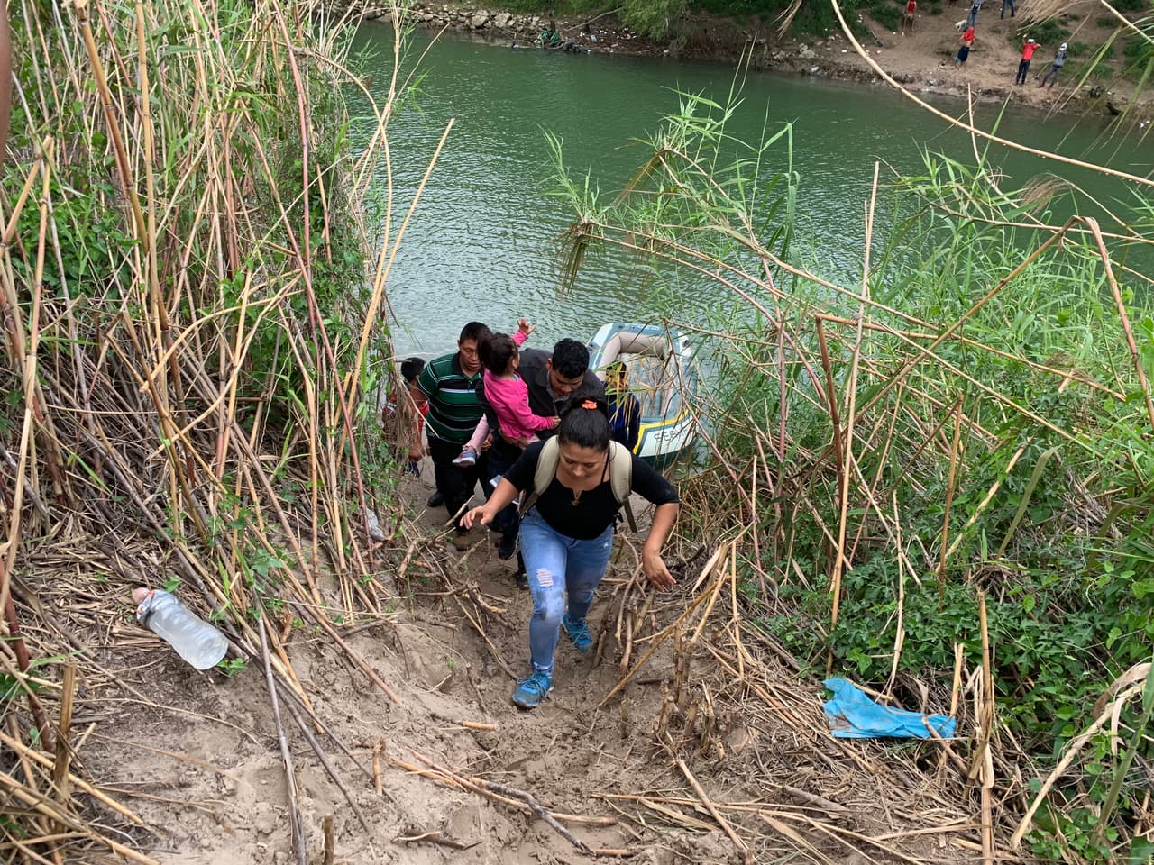Tras cruzar el río, se apresuran por un sendero demarcado entre los matorrales por las pisadas de otros cientos de inmigrantes que rutinariamente atraviesan este sector.