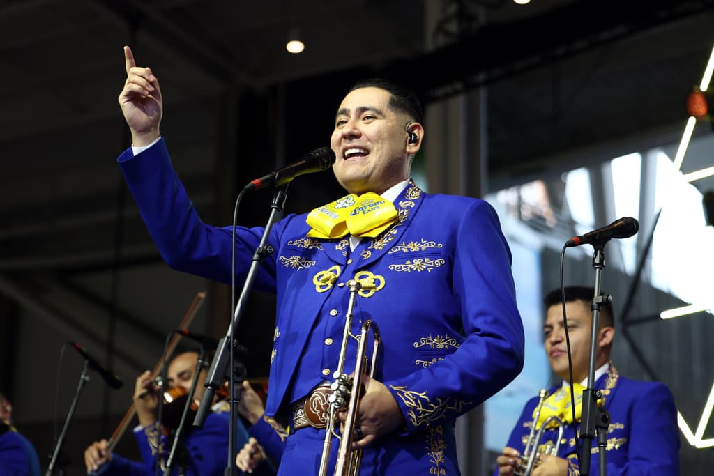 El conjunto de diez músicos de los Mariachi Rams viste trajes de charro tradicionales mientras interpreta canciones como"California Love" de Tupac Shakur en una versión con trompetas, guitarrón y vihuela durante un juego de los Rams en casa.