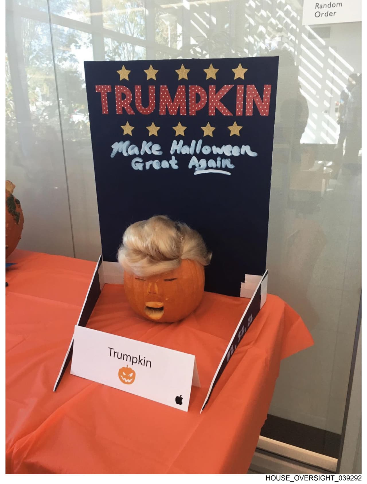 Una calabraza con una peluca debajo de una pizarra que dice "Trumpkin", juego de palabras entre el apellido Trump y 
<i>pumpkin, </i>calabaza en inglés.