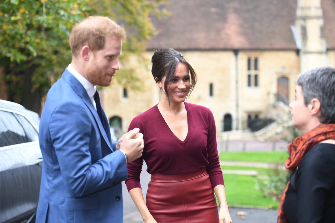 Markle optó por 
<b><a href="https://www.univision.com/famosos/desvistiendo-a-meghan-markle-lo-que-revela-un-ano-de-ropa-de-la-duquesa-de-sussex" target="_blank">combinar la falda</a></b> con un top de punto rojo oscuro de la firma Joseph.