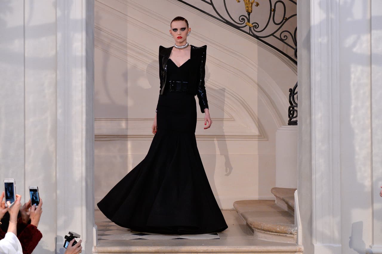 Inspirados en el vestido negro de amplia cola creado por Vera Wang, que eligió la Primera Dama el año pasado, escogimos como primera opción para la cena de estado de hoy este vestido de la casa Saint Laurent presentado recientemente en las pasarelas de París. Una mezcla perfecta entre elegancia clásica pero deslumbrante. Aunque el corte es tradicional el toque de las hombreras en forma de triángulo lo hacen moderno.