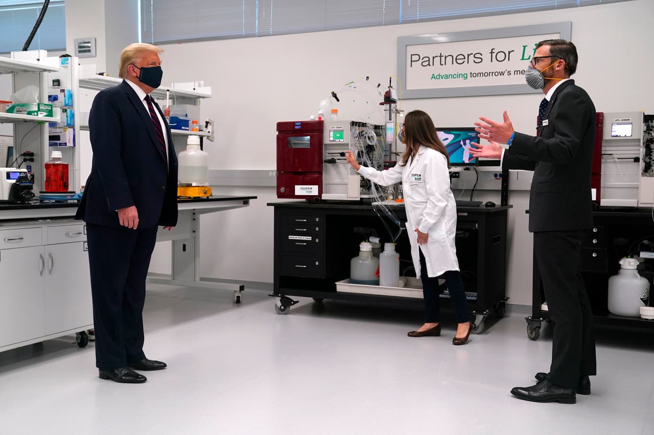 Martin Meeson, CEO de Fujifilm Diosynth Biotechnologies, a la derecha, habla mientras el presidente Donald Trump usa una máscara facial durante un recorrido por el Centro de Innovación de Bioprocesos en Fujifilm Diosynth Biotechnologies, el lunes 27 de julio de 2020, en Morrisville.