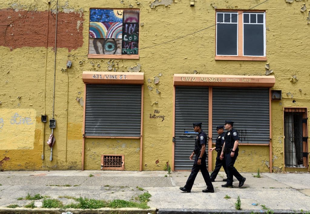 Camden County Police Department officers Vidal Rivera, Louis Sanchez and Jose Delvalle are seen on foot patrol in Camden, New Jersey, on May 24, 2017. In 2013 the city of Camden, New Jersey, dissolved its police force, replacing it with a new county-run department where they are turning around a city that had one of the highest crime rates in the country. Police reform and falling crime statistics turned Camden into a poster child for better policing. / AFP PHOTO / TIMOTHY A. CLARY / TO GO WITH AFP STORY by Jennie MATTHEW, US-politics-police (Photo credit should read TIMOTHY A. CLARY/AFP/Getty Images)