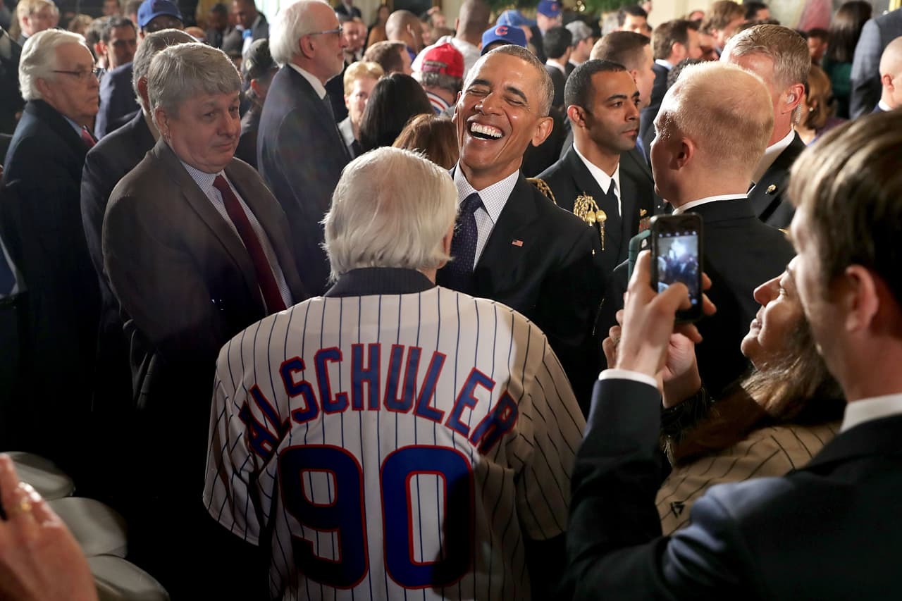 Frank Alschuler, un aficionado de los Chicago Cubs hace reir a Obama durante la celebración.