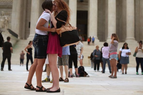Ariel Cronig (I) y Elaine Cleary (D) se besan frente a la sede de la Corte, luego de que los magistrados fallaran a favor de la demanda, con cinco votos a favor y cuatro en contra.