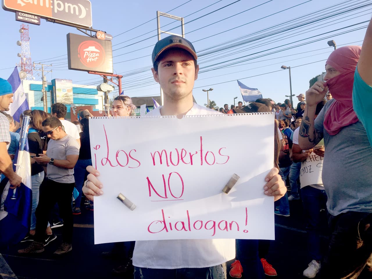 'The dead can't dialogue' . Fernando Sánchez, a communications student from the Central American University (UCA) made a banner with two bullet casings that he picked up last week after the police opened fire on students taking refuge in the cathedral of Managua.