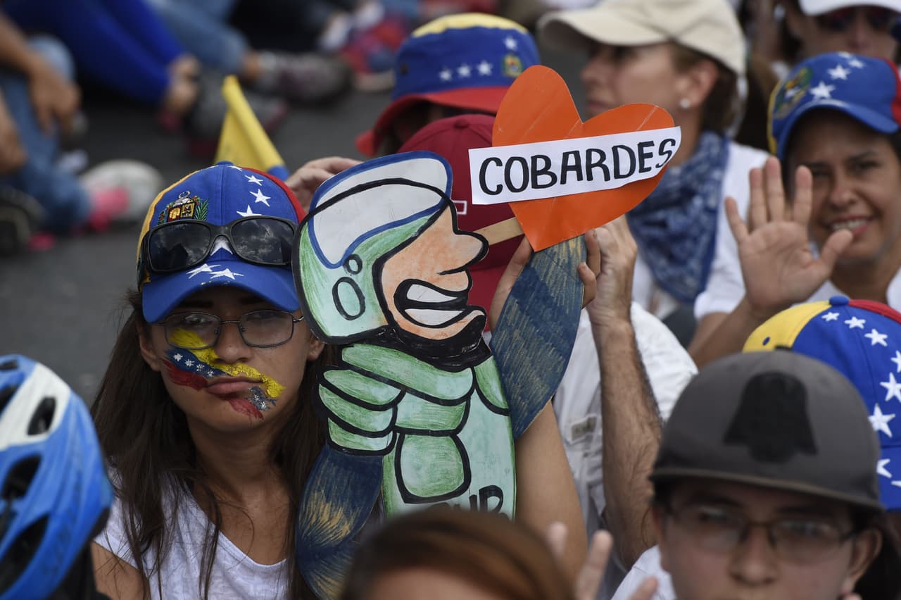 "Cobardes", se lee en esta pancarta que acompaña el dibujo de un guardia nacional. La represión ha recrudecido en los últimos días de protestas. Ha habido heridos y muertos por impactos de bombas lacrimógenas, y
<a href="http://www.univision.com/noticias/protestas/un-muerto-dos-jovenes-quemados-y-uno-bajo-una-tanqueta-militar-recrudece-la-violencia-en-las-protestas-en-venezuela">un manifestante fue arrollado por una tanqueta</a>.