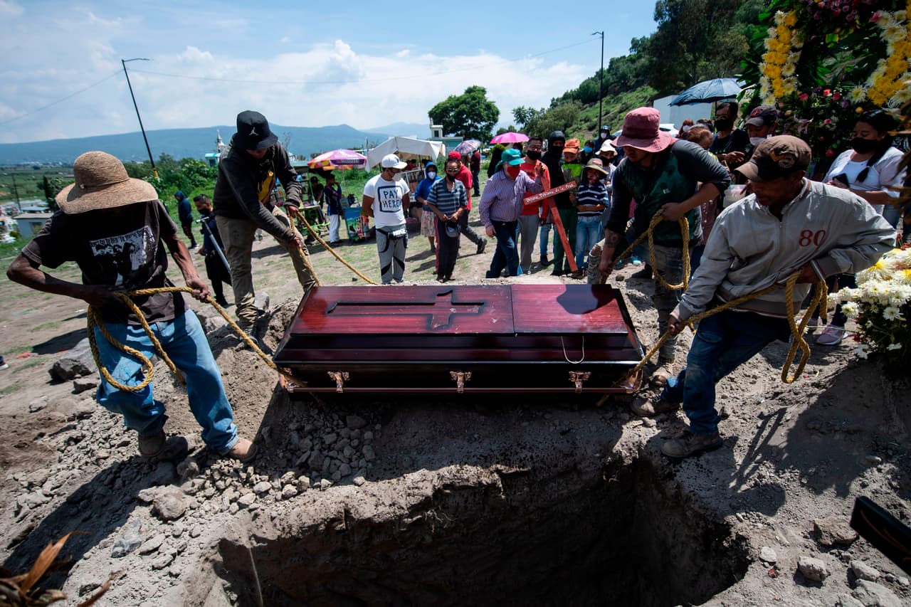 Sepultureros mueven un ataúd durante un funeral en el cementerio de San Miguel Xico, en medio de la pandemia de coronavirus.
<br>
<br>En una entrevista con la agencia AFP, José Pérez, panadero de 40 años, cuenta que pasó de la incredulidad a la tragedia cuando murieron sus dos hermanas por el coronavirus. En un mismo terreno están las casas de cinco hermanos. En mayo, todos enfermaron. Adriana, de 43 años, y Guadalupe, de 48, fallecieron.
<br>
<br>
<br>