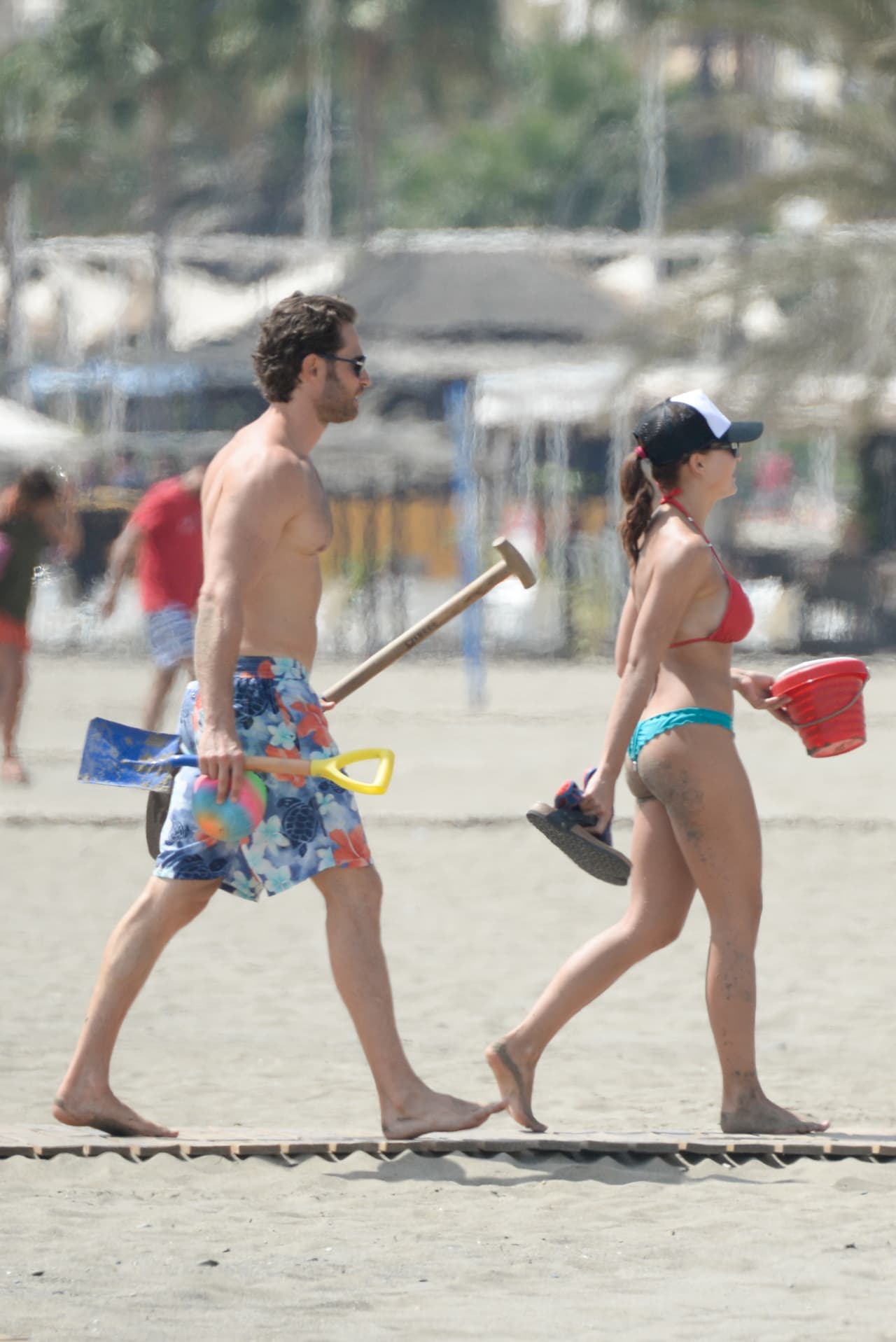 Con palas, listos para hacer un hoyo en la arena.