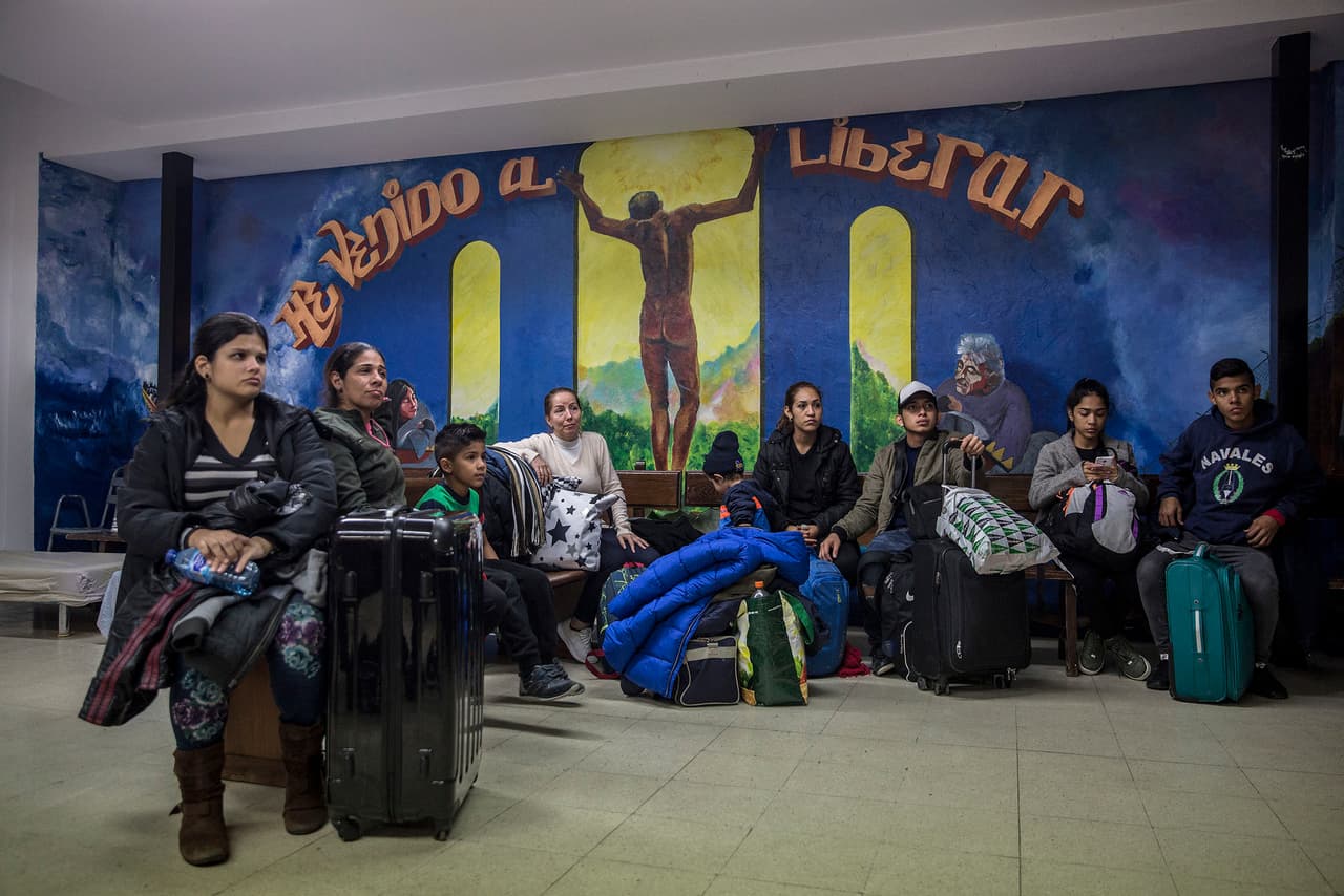 Salvadoran, Venezuelan and Colombian families along with their suitcases and belongings, inside the San Carlos Borromeo Parish where they were received by the parish priest Javier Baeza.