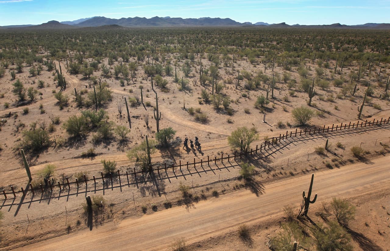 Inmigrantes caminando por la frontera retratados desde un helicóptero.