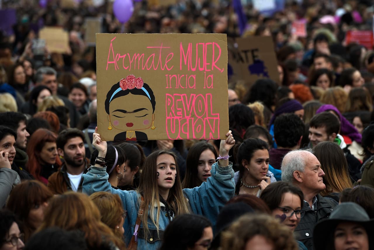 Una manifestante sostiene un cartel con un dibujo de Frida Kahlo junto a la frase
<b>"á(r)mate mujer, inicia la revolución" durante una manifestación para defender los derechos de las mujeres en el Día Internacional de la <a href="https://www.univision.com/temas/derechos-de-la-mujer">Mujer</a></b> en Barcelona.